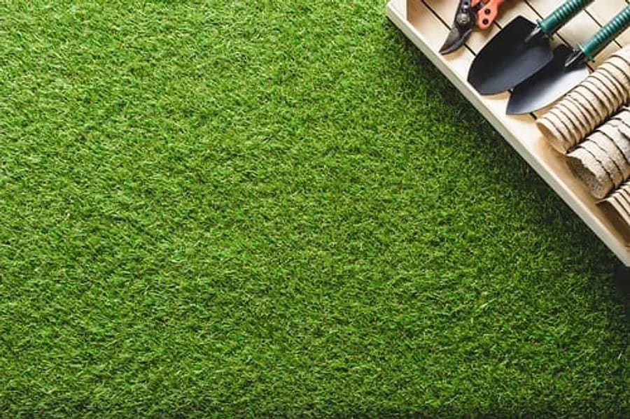 Freshly installed artificial turf lawn with landscaping hand tools in Mesa, AZ